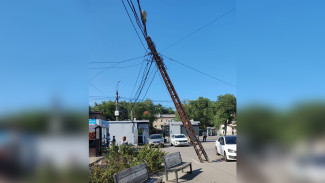 Столб опасно повис на проводах у рынка в Воронеже