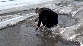 В Воронеже девушка измерила глубину ям на улице Владимира Невского
