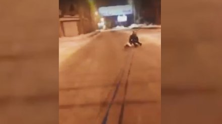 Жительница Воронежа прокатилась по заснеженной дороге на привязанном к авто тюбинге